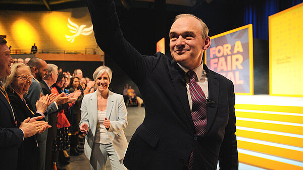 Ed Davey waves to an applauding audience as he leaves the stage after making a conference speech