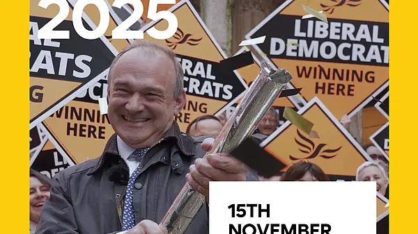 Front cover of East of England regional conference agenda featuring Ed Davey with a confetti cannon in front of a crowd of people holding Liberal Democrat diamond-shaped posters