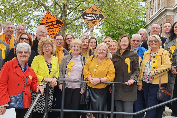 A varied group of Liberal Democrats many wearing gold rosettes on the steps outside Chelmsford council offices