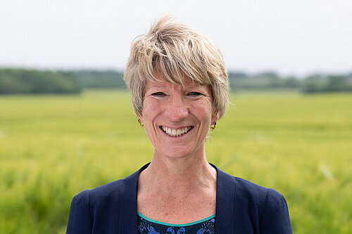 Pippa Heylings writes to Anthony Browne to demand safeguards for wildlife Head and shoulders photo of Pippa Heylings, Lib Dem Parliamentary candidate for South Cambs. Pippa is smiling at the camera, standing in front of a grassy field with trees in the distance.