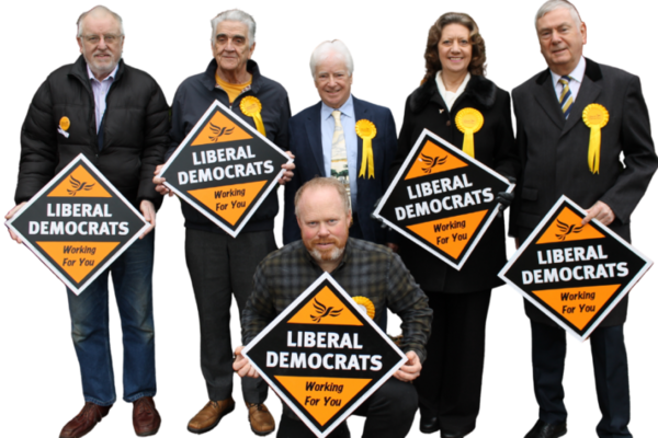 A group of six Lib Dems holding diamond shaped Lib Dem posters