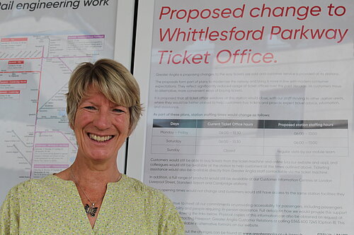 Pippa Heylings, Liberal Democrats parliamentary candidate for South Cambridgeshire, stands in front of an announcement about changes to the Whittlesford Parkway ticket office