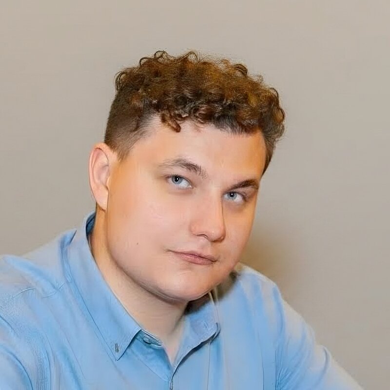 Jakub Makowski sitting at a table looking at the camera wearing a light blue polo shirt 